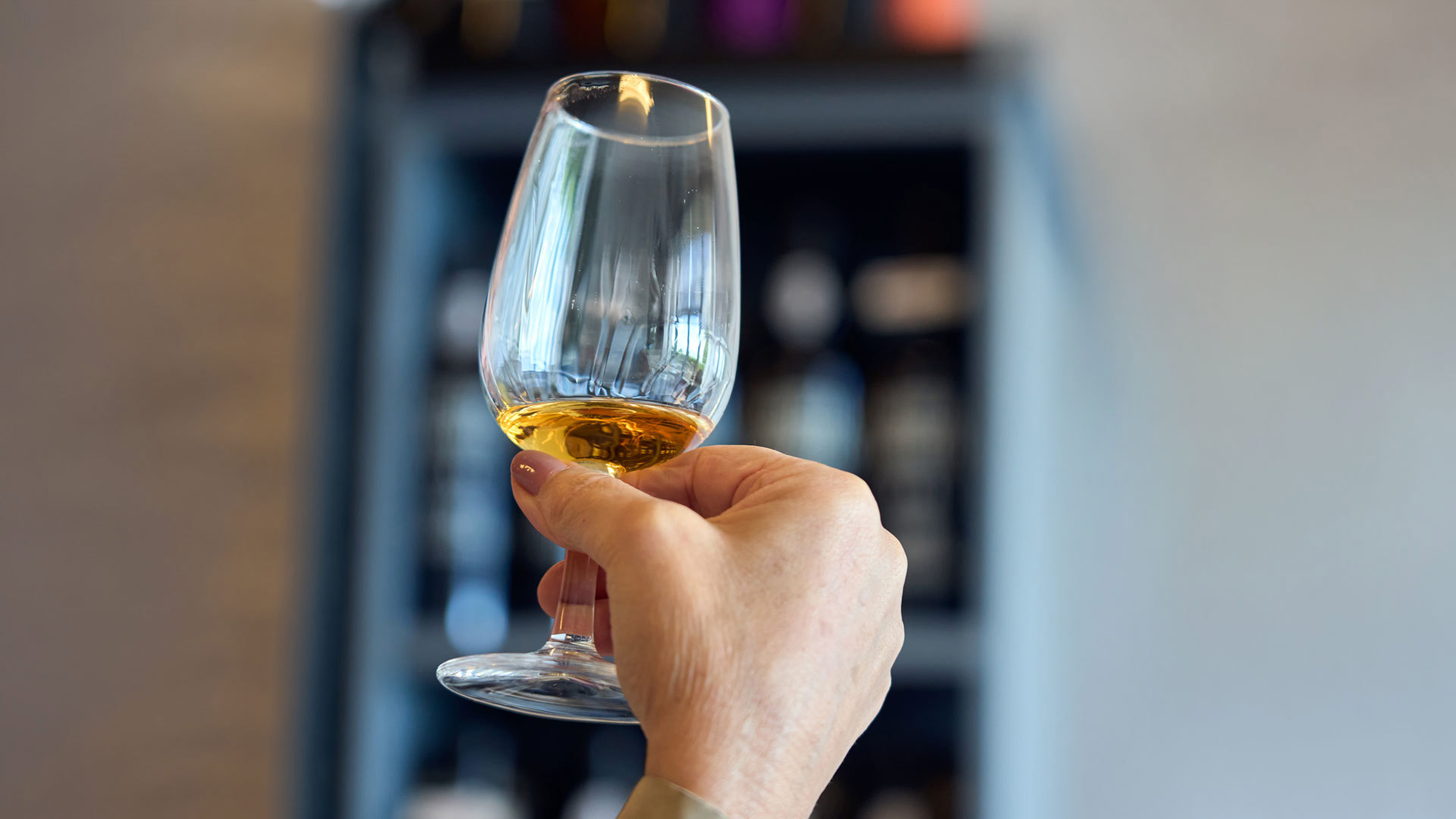 Hand holding a glass of Madeira wine.