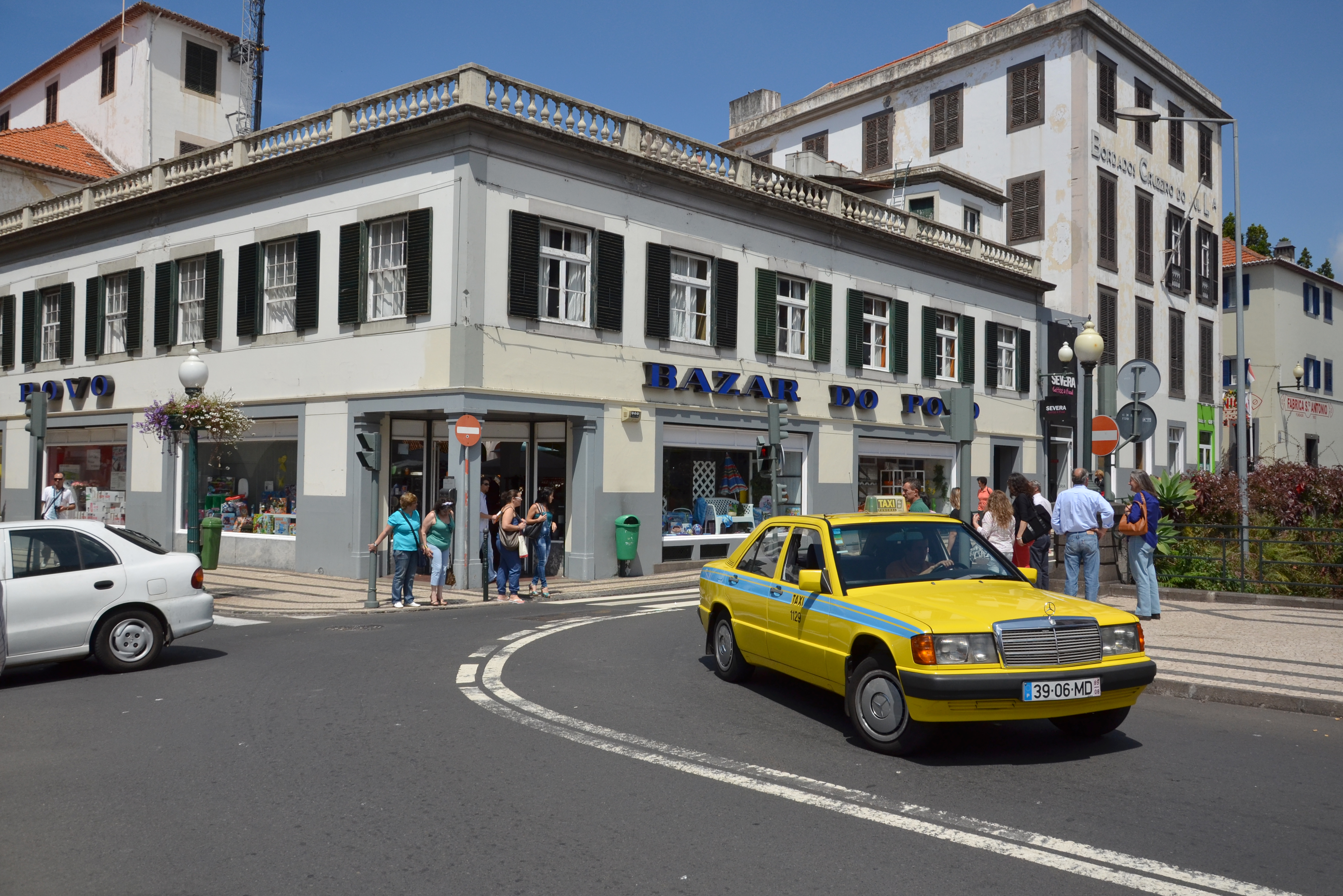 Coche amarillo en la carretera con personas en Madeira.