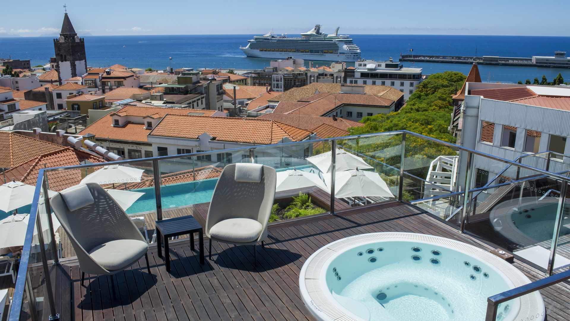 Jacuzzi com edifícios e navio de cruzeiro ao fundo na Madeira.