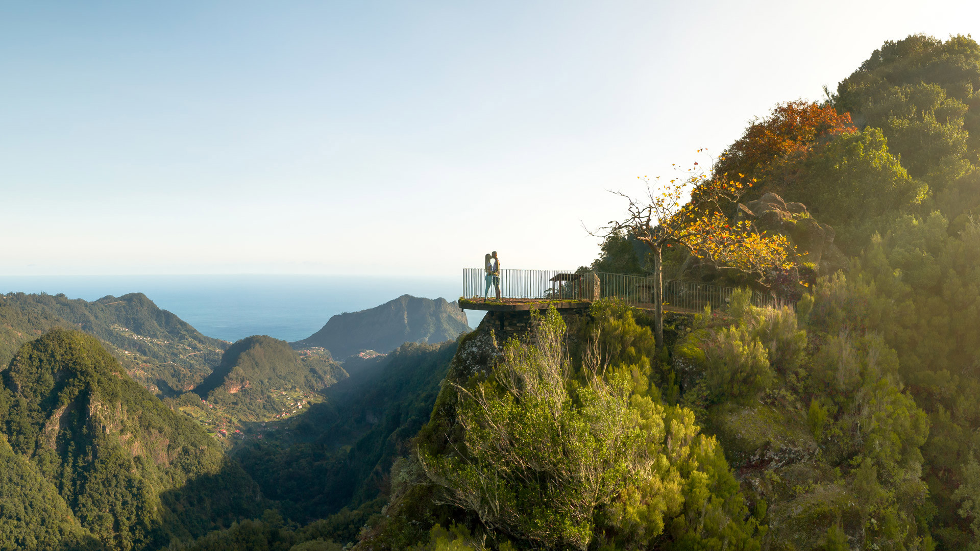Montanhas verdes e laranjas com sol no miradouro na Madeira.