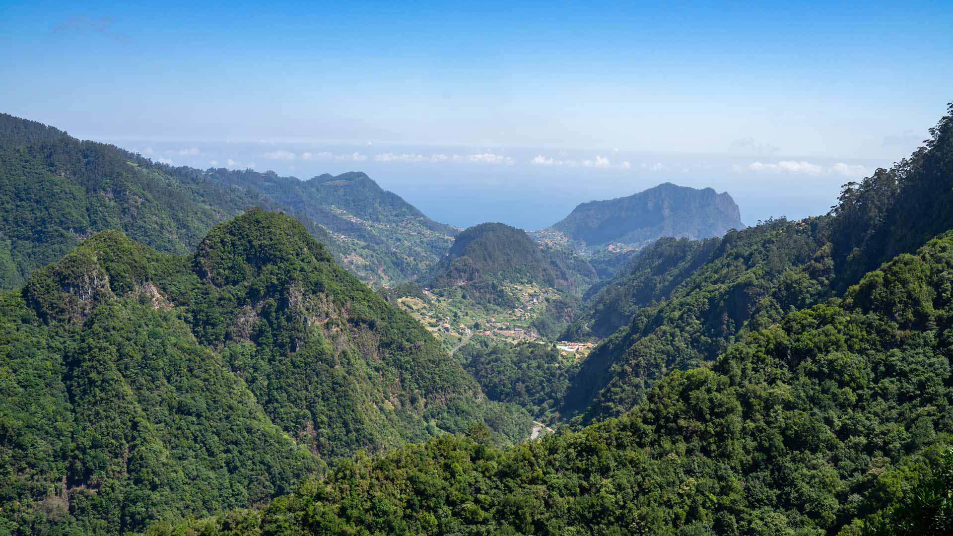 Montañas verdes con valle bajo cielo en Madeira.