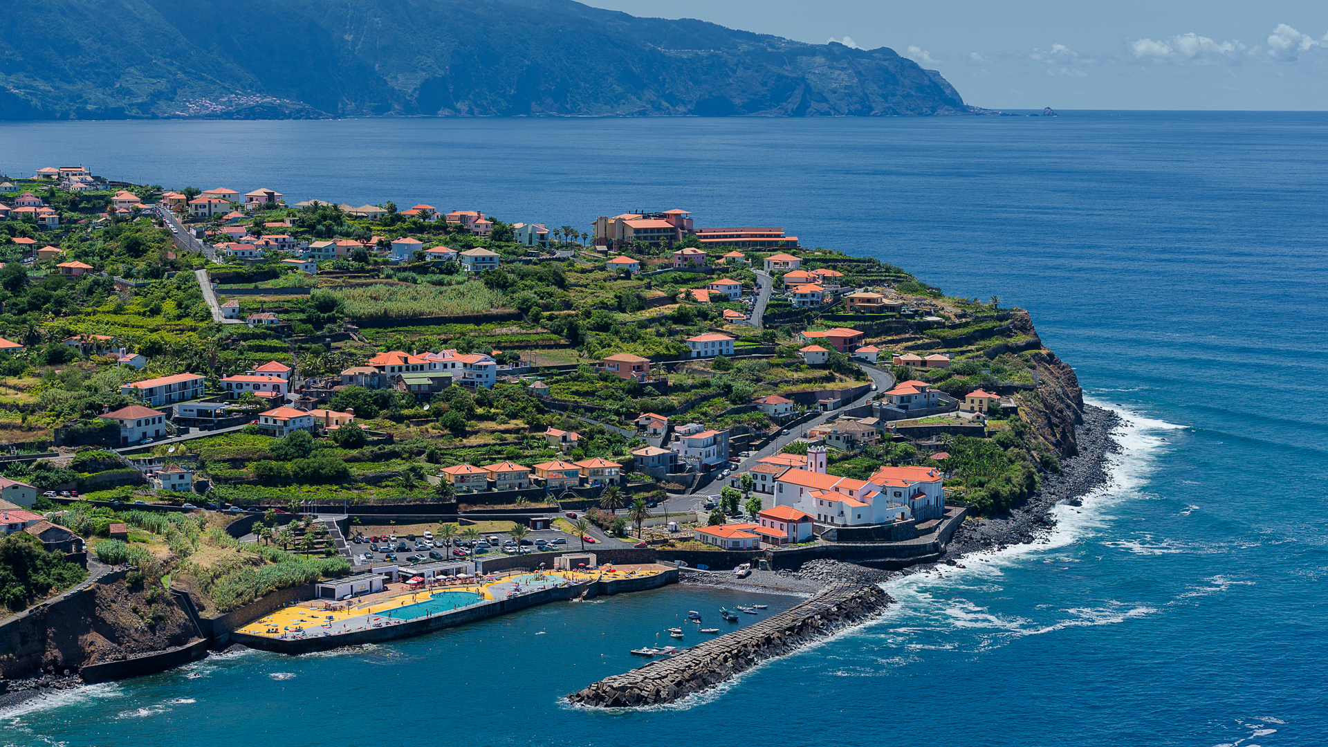 Encosta com casas e vista para o mar.