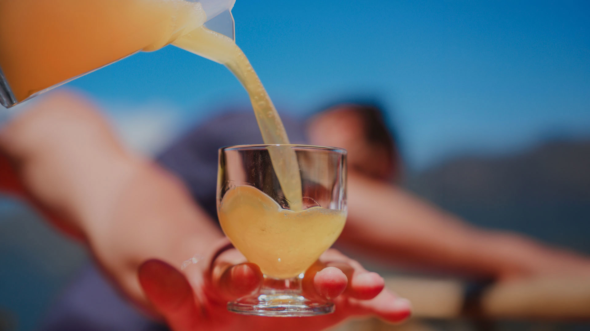 Poncha being poured from a jug into a glass on Madeira Island.