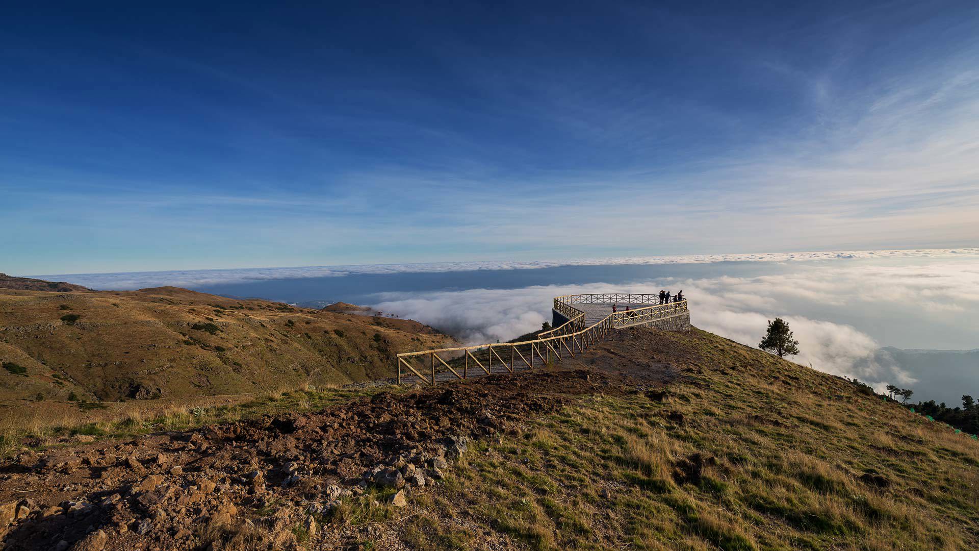 Belvédère du Paredão avec vue sur Funchal, montagnes, végétation et ciel bleu.