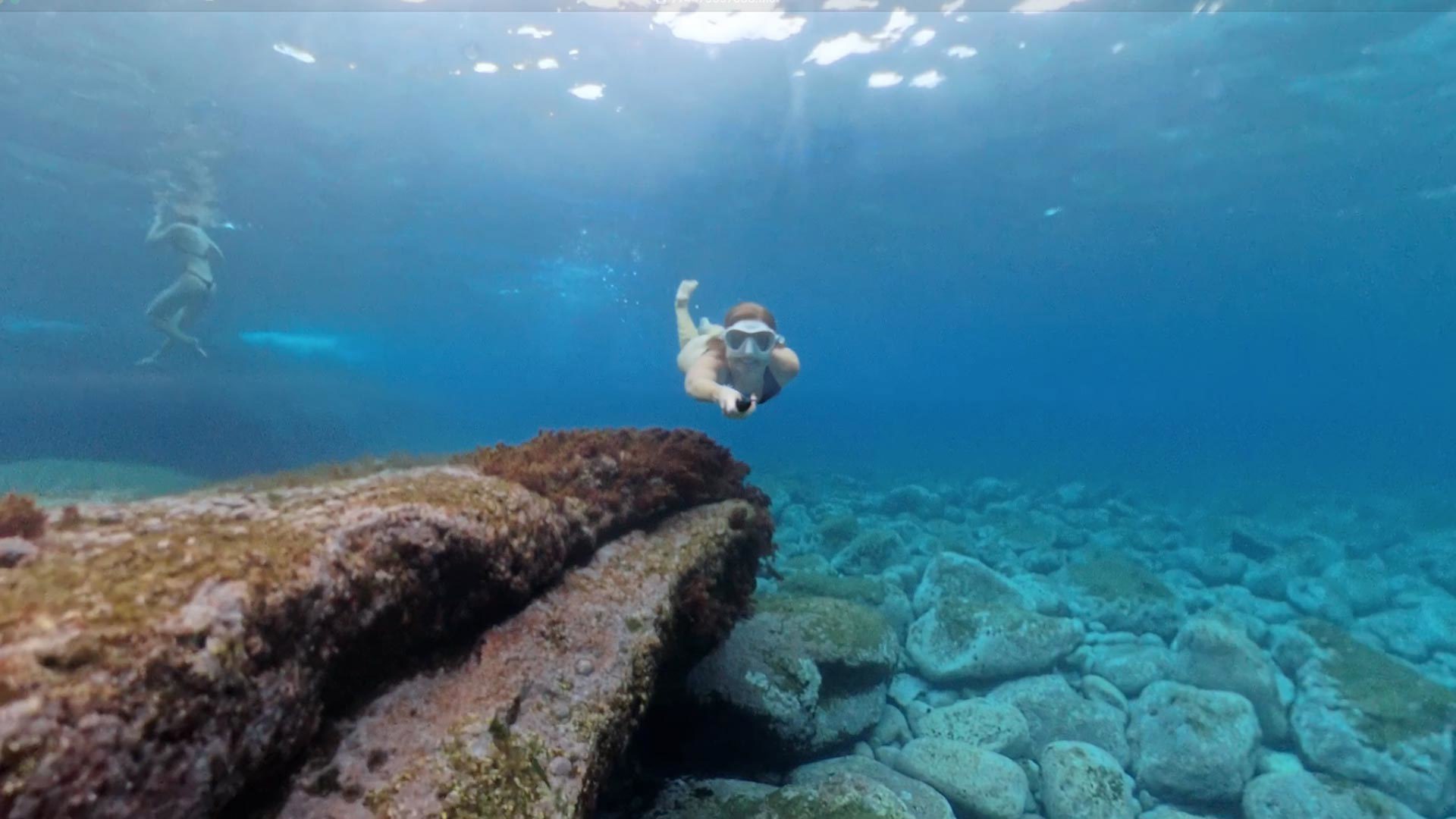 Mulher a fazer snorkelling no mar com equipamento completo.