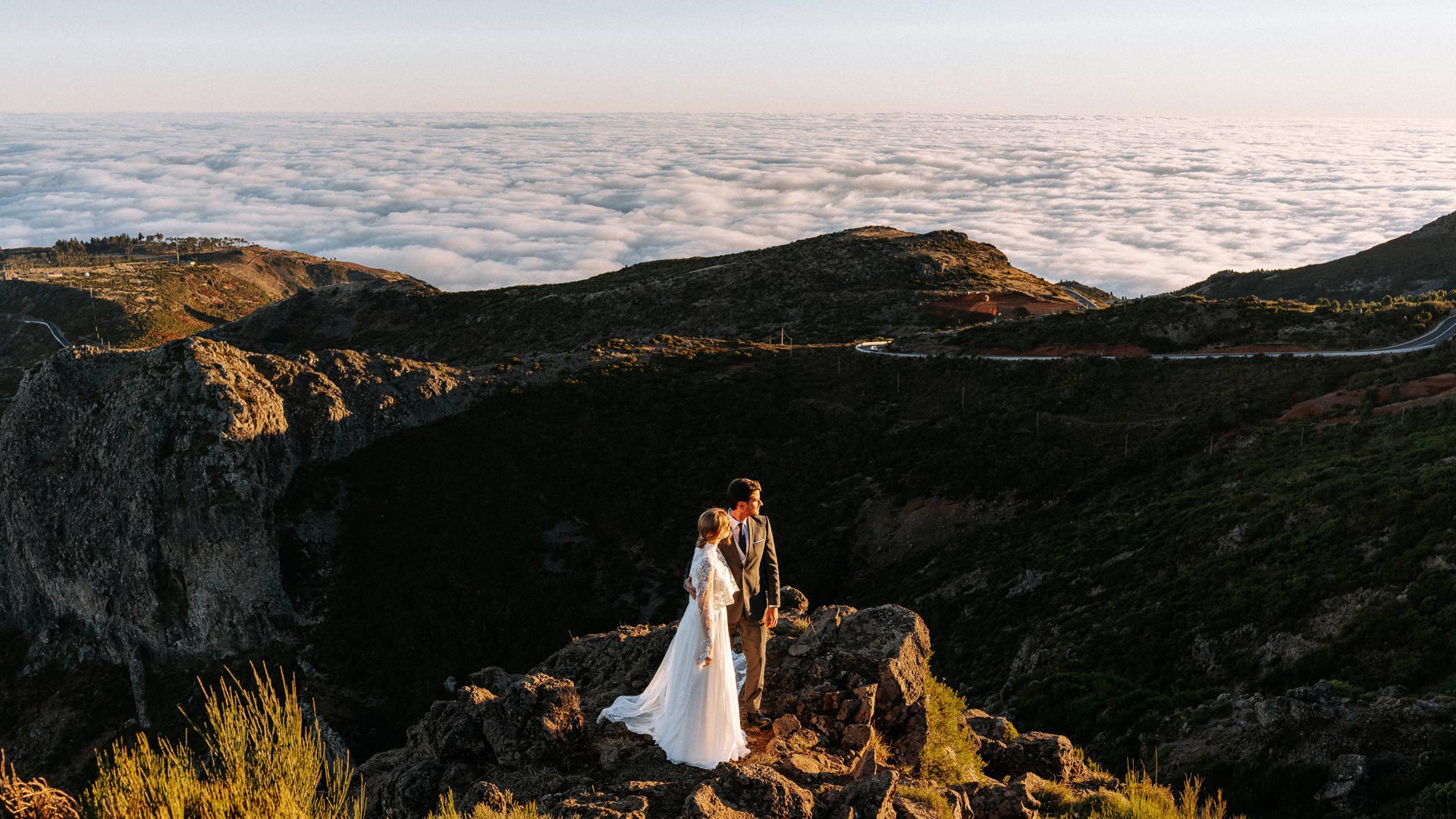 Couple in wedding attire in the mountains above the clouds.