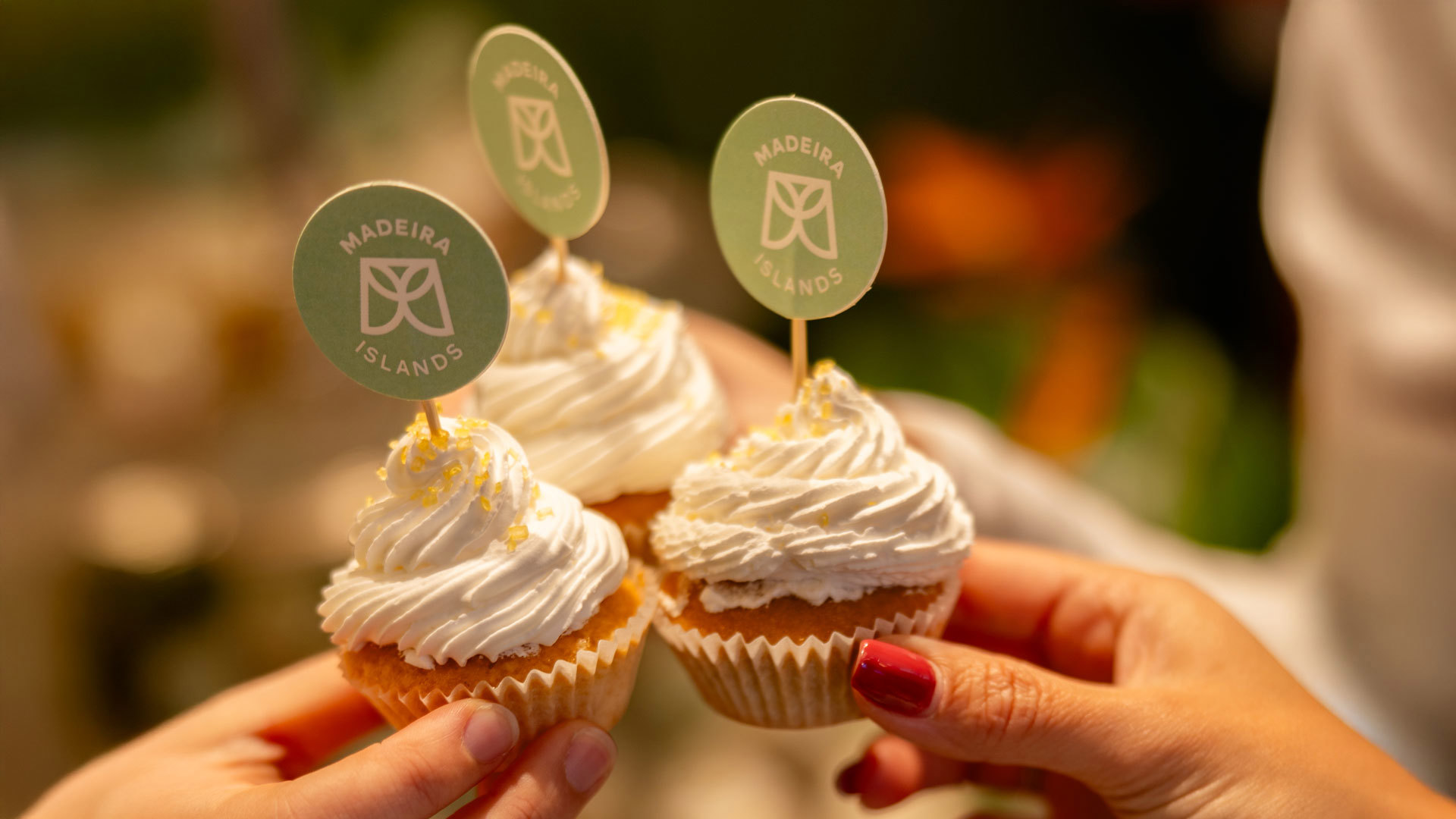 Drei Cupcakes mit Glasur und Madeira-Logo in der Touristeninformation Madeira in Lissabon, anlässlich eines Jubiläums.