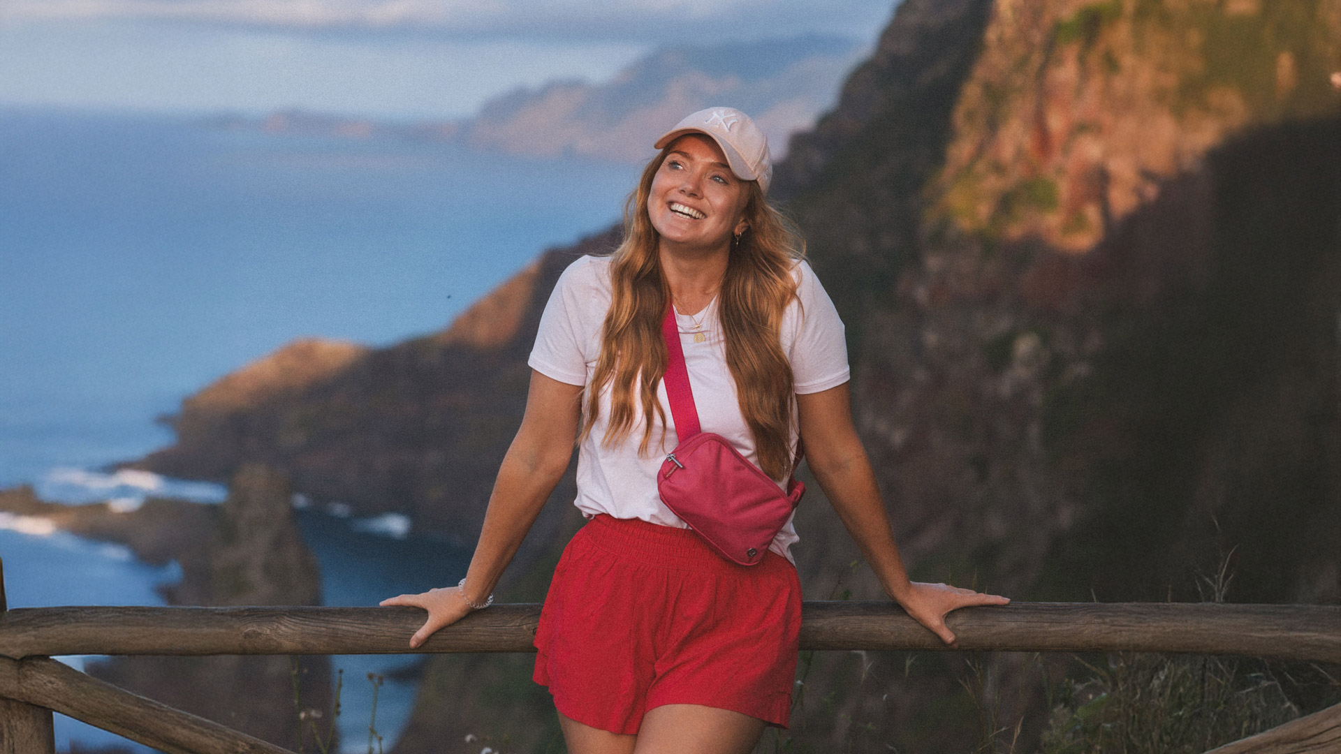 Mulher a apreciar a paisagem da Rocha do Navio, usando chapéu.