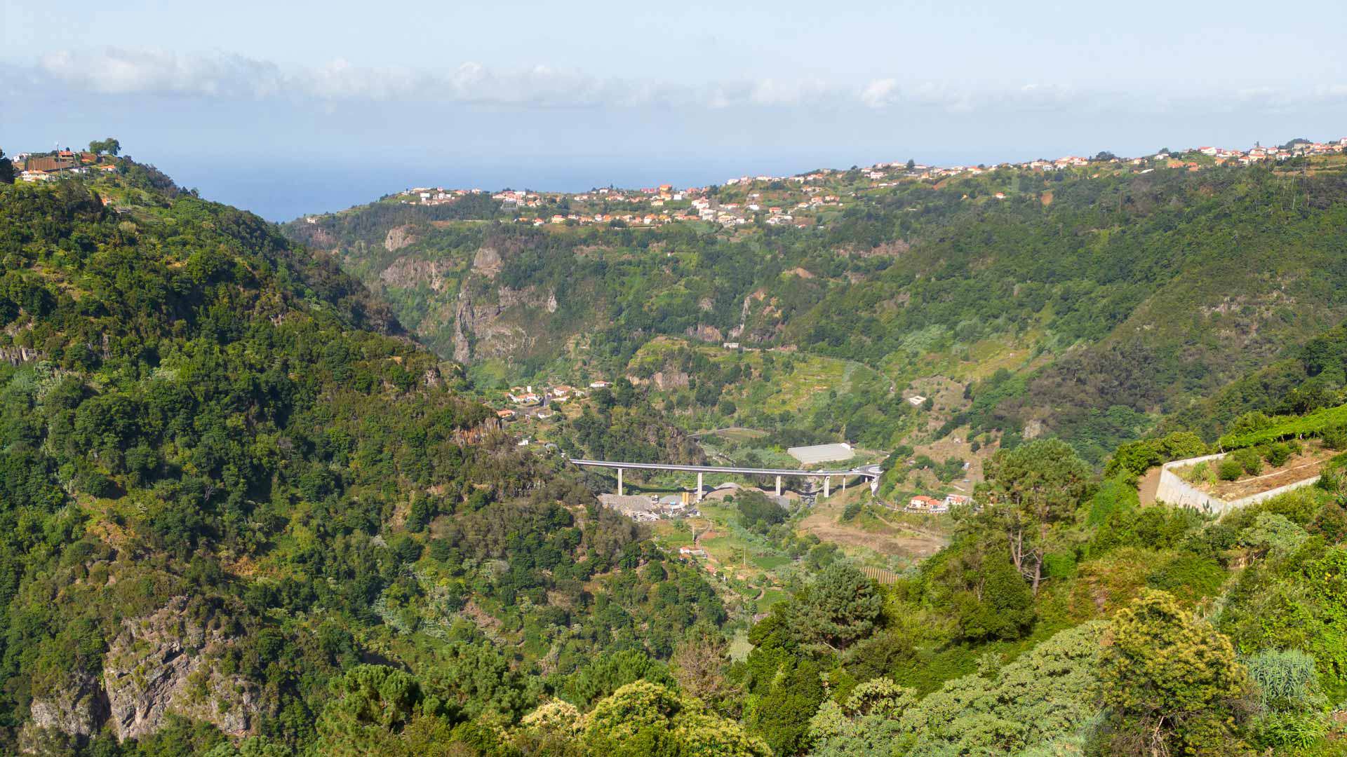 Montañas con vegetación verde y puente en Madeira.