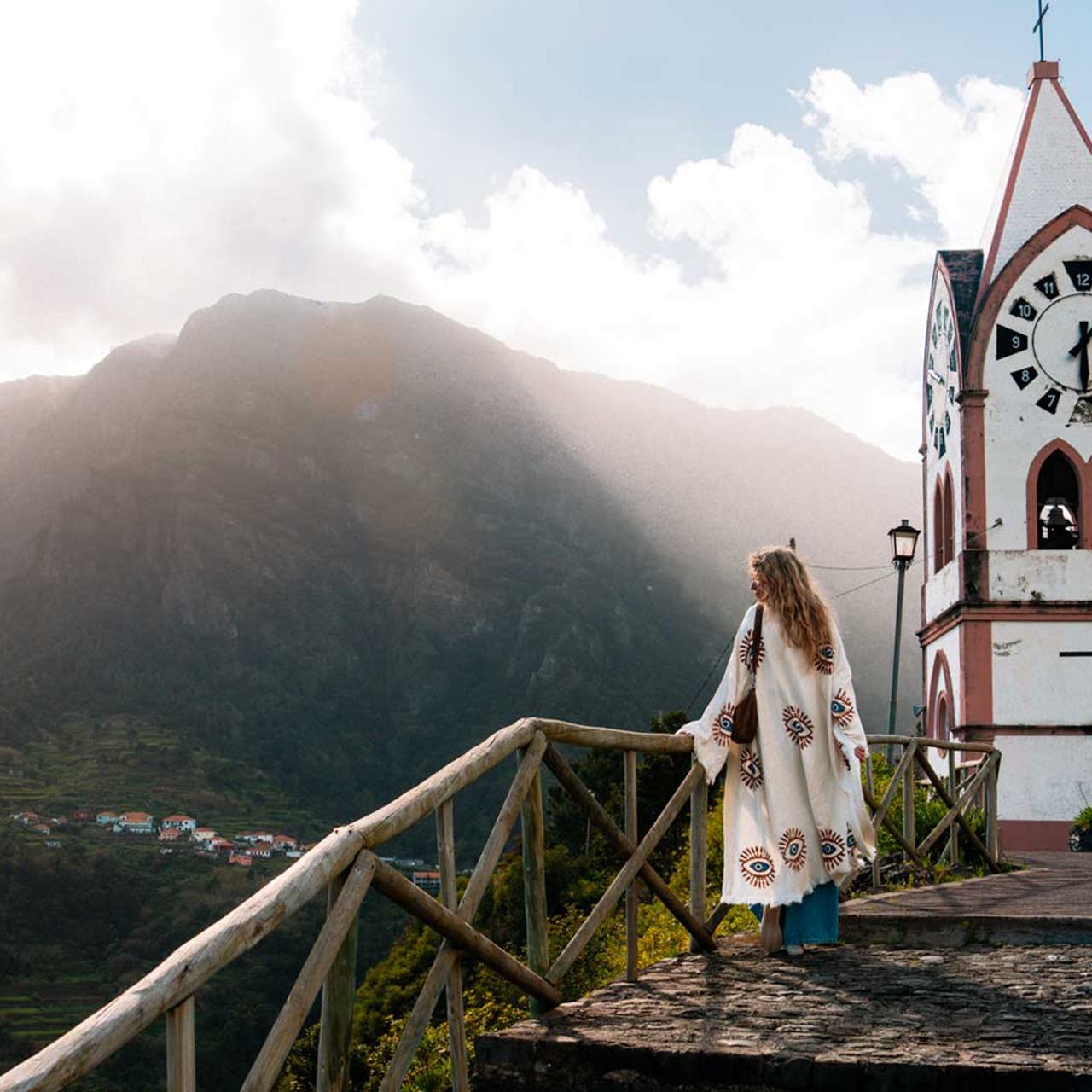 Church surrounded by nature with a woman enjoying the sunny landscape on Madeira Island.