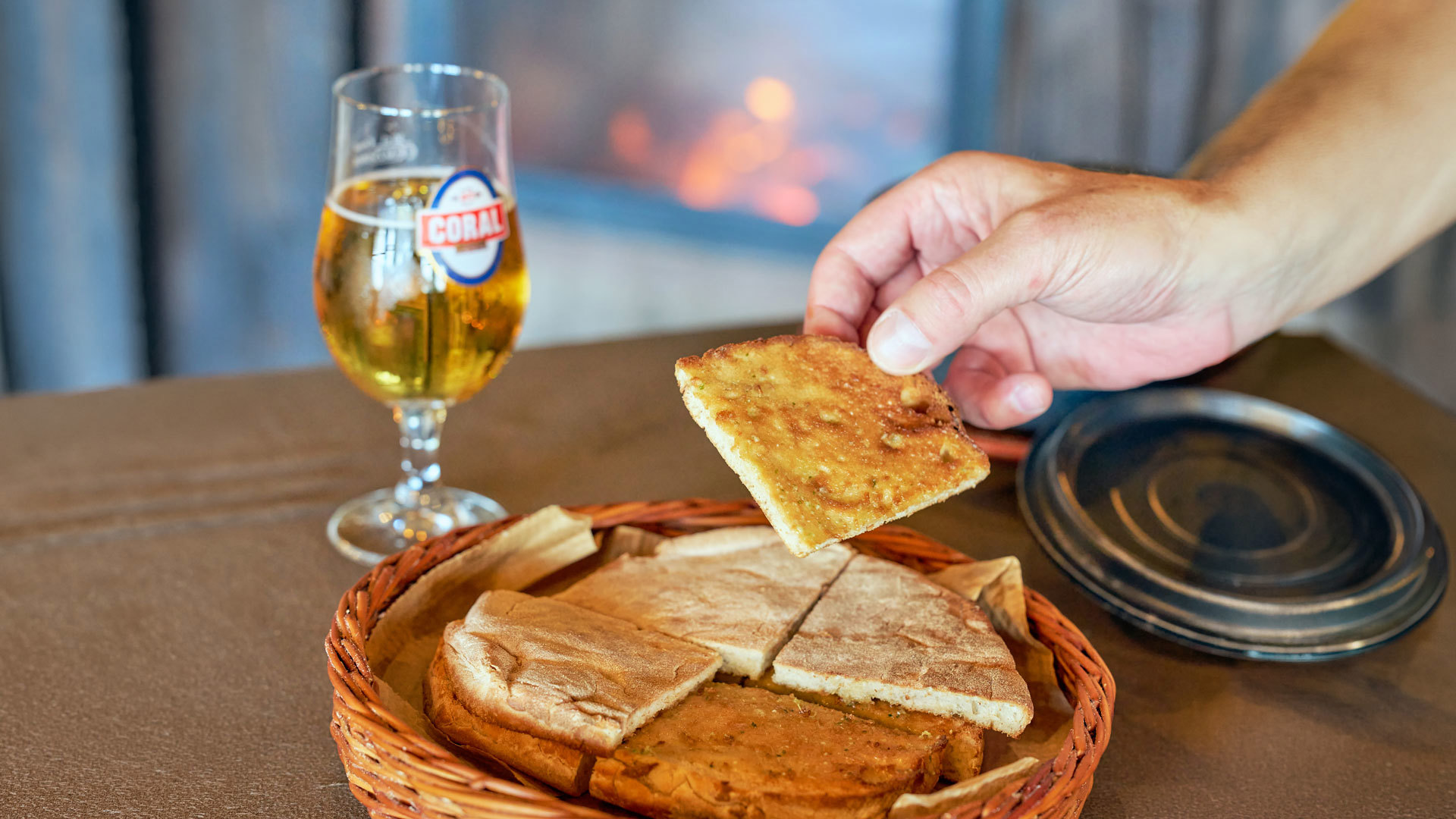 Bolo do caco con mantequilla de ajo acompañado de una cerveza.