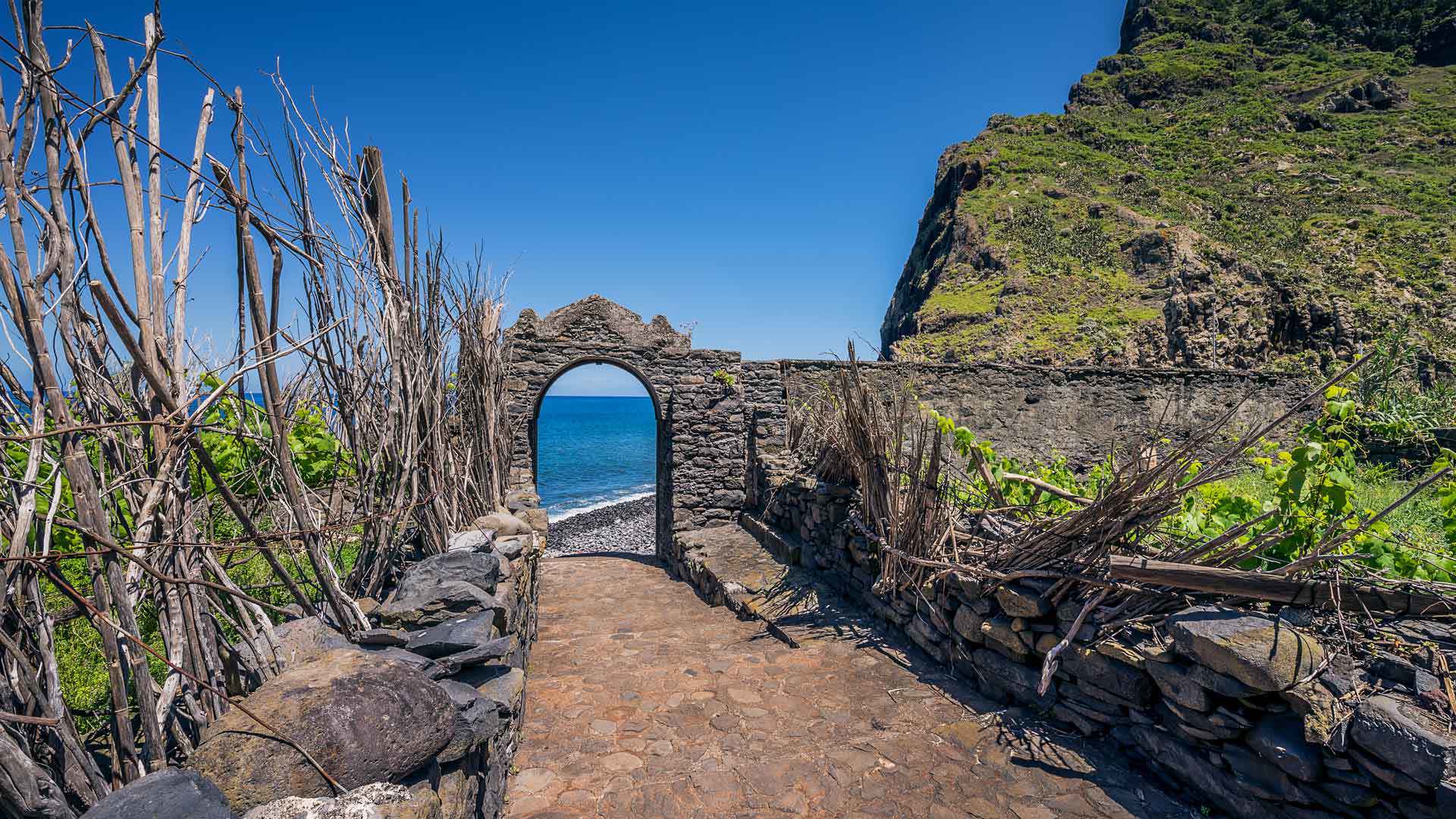 Treppen neben Steinbogen mit Meerblick auf Madeira.