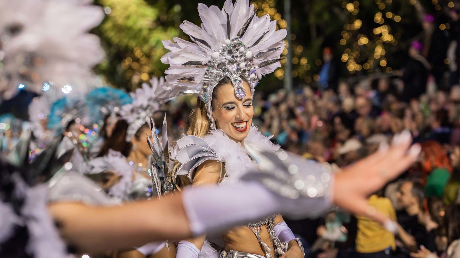 Women in costume taking part in a Carnival parade at night in Funchal, Madeira.