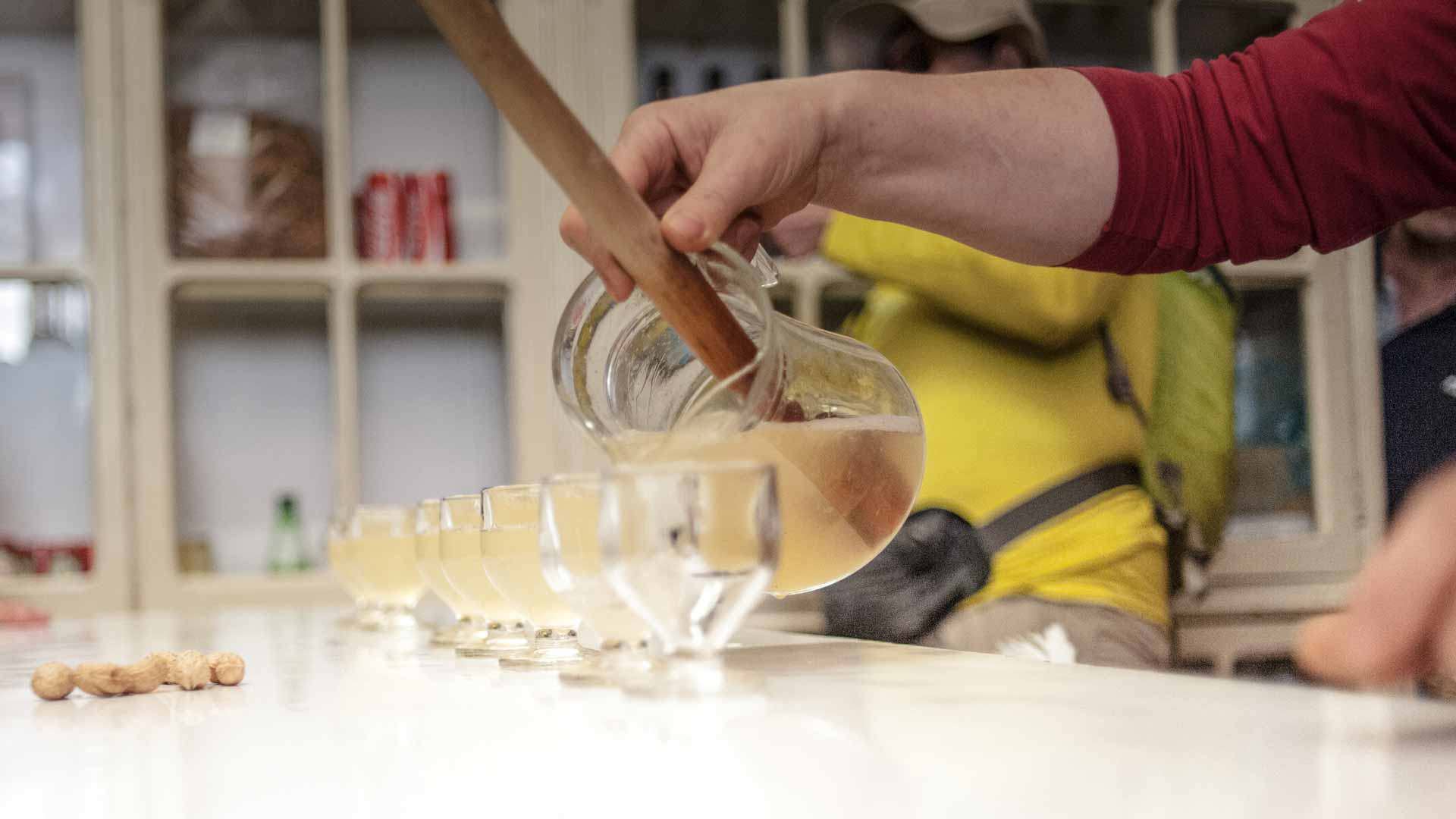 Fisherman's poncha being poured into glasses during a traditional Madeira preparation.