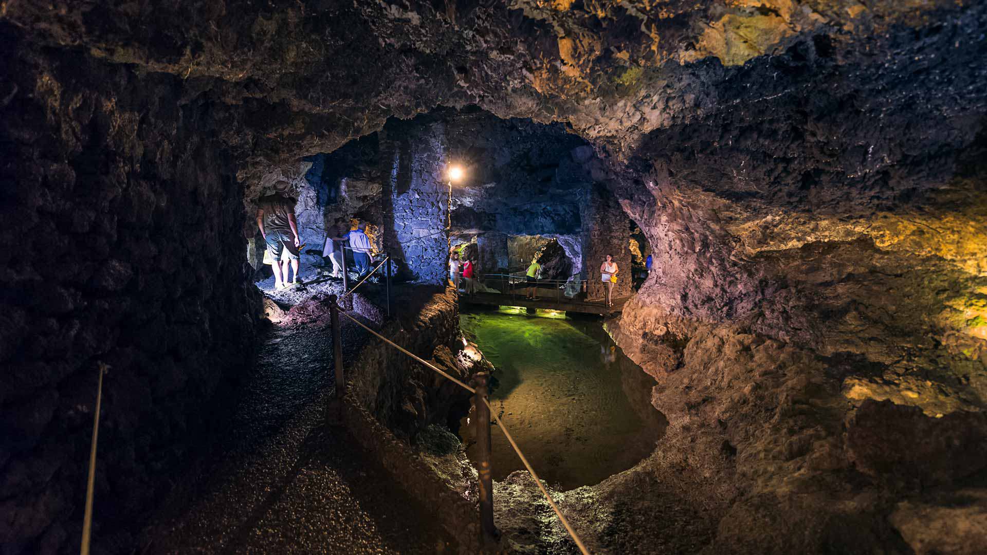 Illuminated cave with visible rock formations.