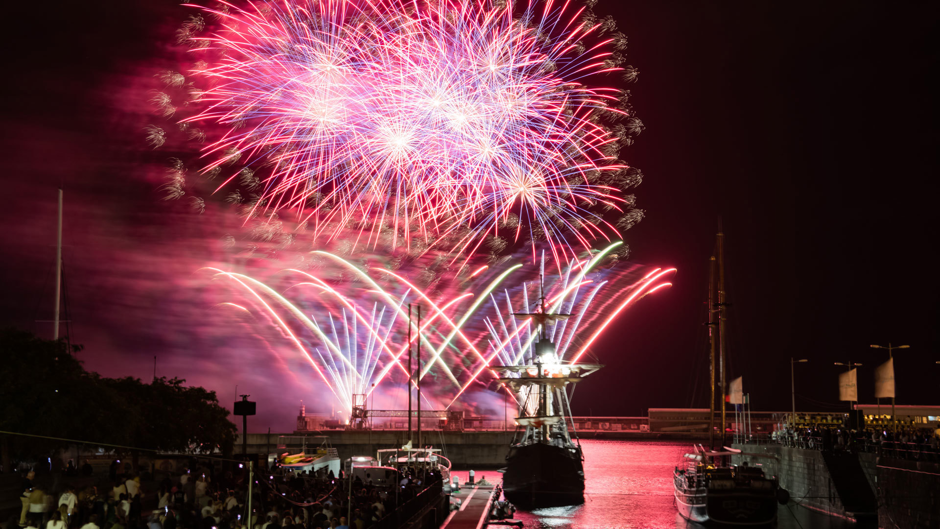 Bateau dans la marina de nuit avec feux d’artifice lors du Festival de l’Atlantique.