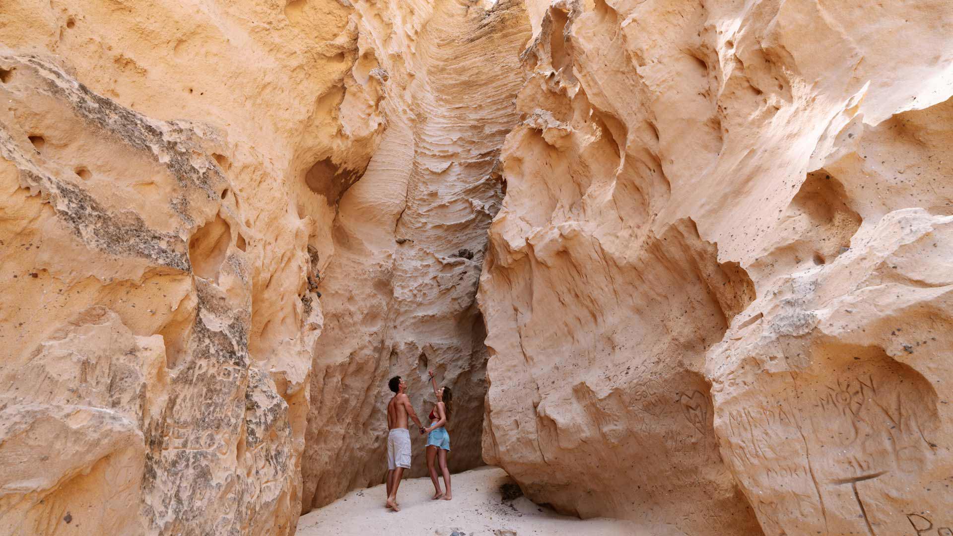 Couple near a geological fissure in a sandy area