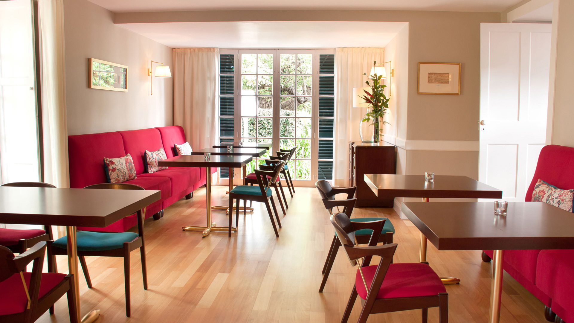 Mesas, sillas y sofás rojos dispuestos en el espacio.