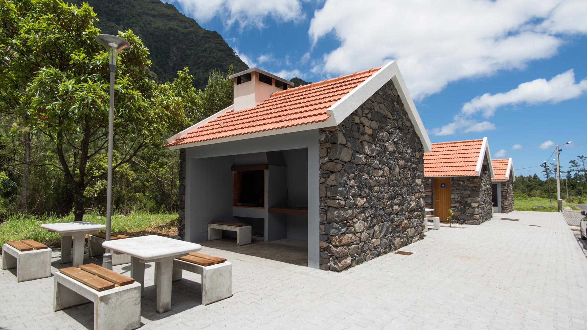 Grillhaus mit Bank und Tisch zum Essen.