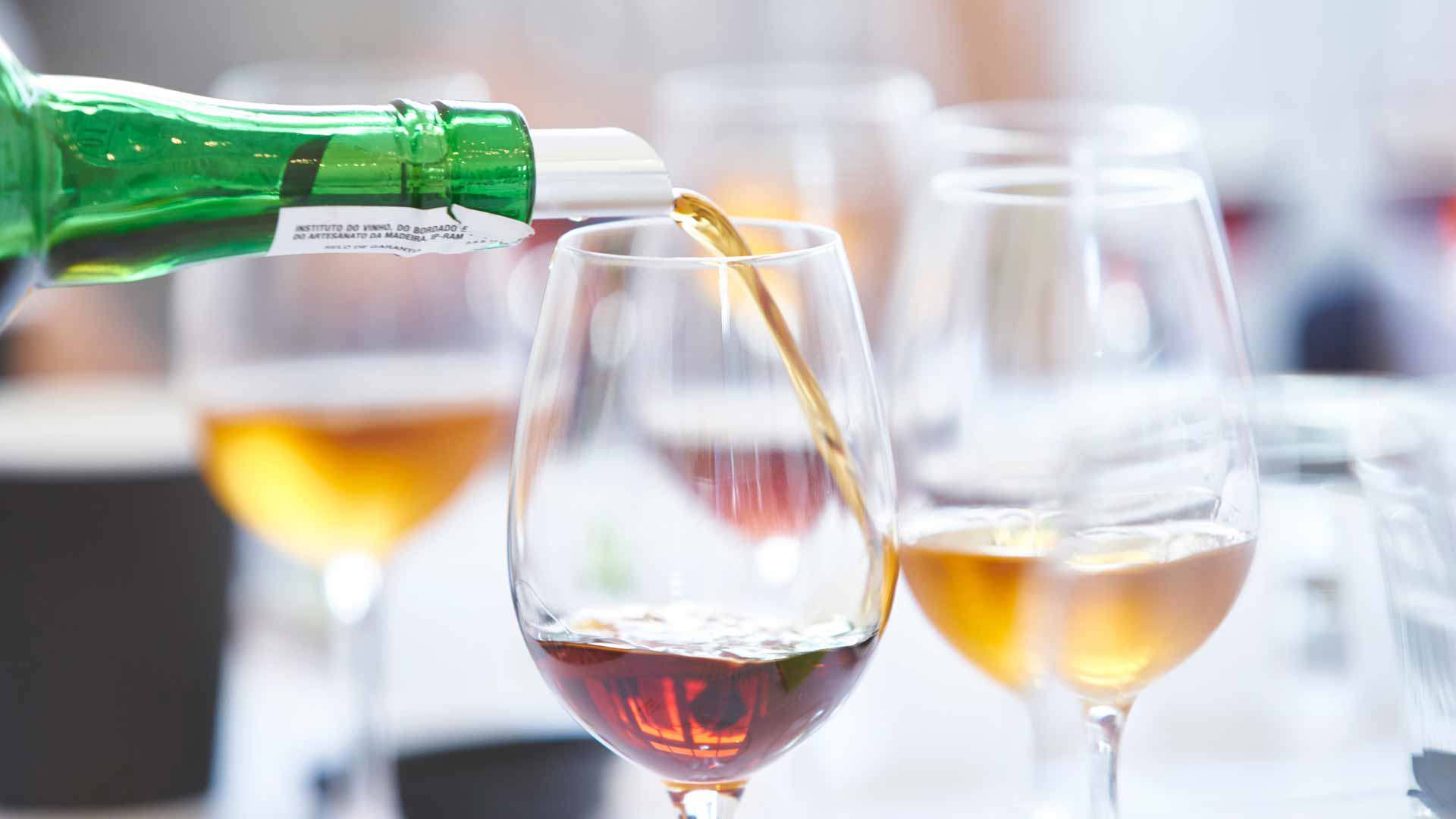 Bouteille versant du vin dans des verres lors d’une dégustation de vin de Madère, sur l'île de Madère.